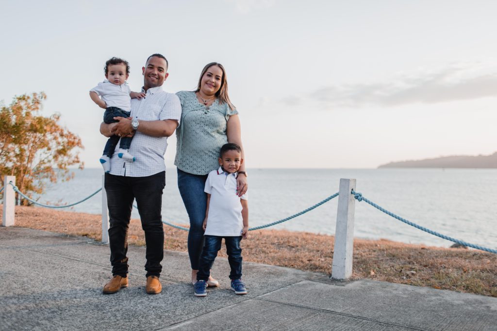 Couple standing on beach with two small children